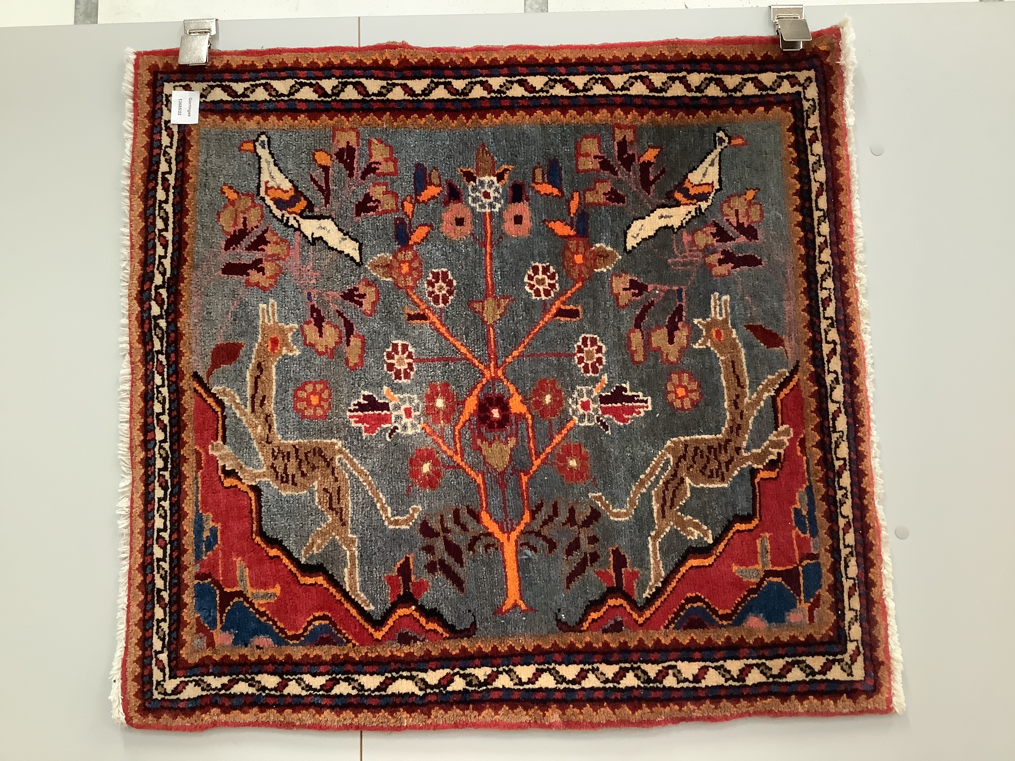 A Persian pictorial blue ground mat, 77 x 84cm